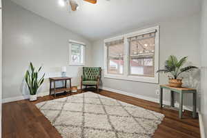 Sitting room with dark wood-type flooring, ceiling fan, and lofted ceiling