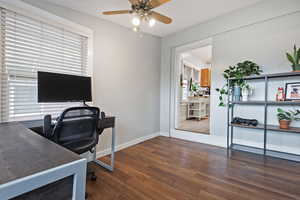 Office area featuring dark wood-type flooring and ceiling fan