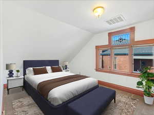 Bedroom with lofted ceiling and light carpet