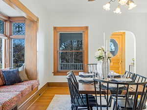 Dining room featuring hardwood / wood-style flooring, crown molding, and an inviting chandelier