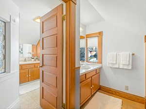 Bathroom featuring vanity and vaulted ceiling