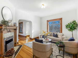 Living room with a brick fireplace and light wood-type flooring