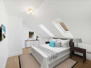 Bedroom featuring vaulted ceiling with skylight