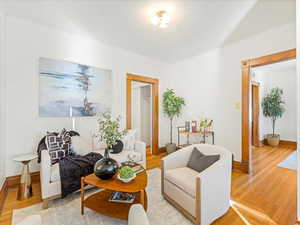 Living room with wood-type flooring and crown molding