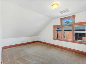 Additional living space with lofted ceiling and carpet