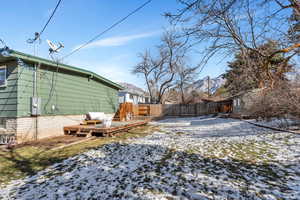 Snowy yard with a deck with mountain view