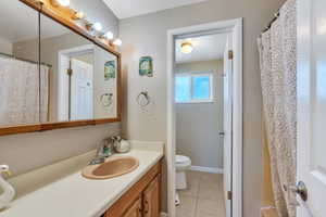 Bathroom with tile patterned flooring, vanity, and toilet