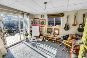 Living area with carpet floors and a drop ceiling