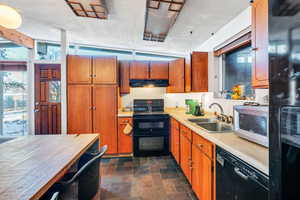 Kitchen featuring sink, a textured ceiling, and black appliances