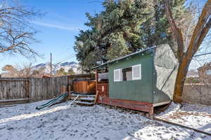 Yard covered in snow featuring a mountain view and a jacuzzi