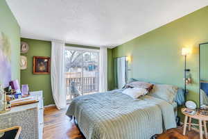 Bedroom featuring hardwood / wood-style flooring and a textured ceiling