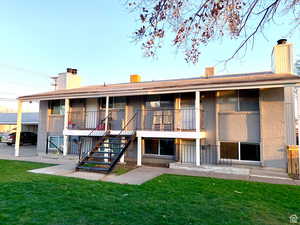 Rear view of house featuring a lawn