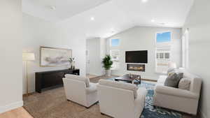 Living room with high vaulted ceiling and light hardwood / wood-style floors