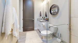 Bathroom with hardwood / wood-style flooring, vanity, and toilet