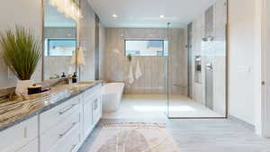 Bathroom featuring vanity, separate shower and tub, and tile walls