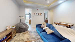 Interior space with connected bathroom, a tray ceiling, and light hardwood / wood-style flooring