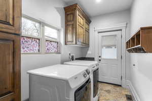 Clothes washing area with separate washer and dryer and cabinets