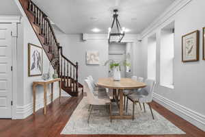 Dining area featuring ornamental molding, hardwood and an inviting chandelier