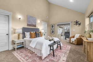 Primary main floor Bedroom featuring multiple windows, high vaulted ceiling, and access to exterior and hot tub