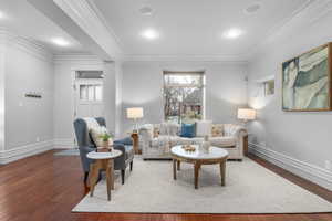 Living room with wood flooring and ornamental molding