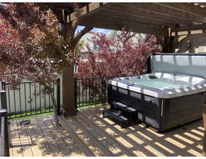 Wooden terrace featuring a pergola and a hot tub