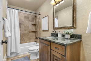 Full bathroom with shower / bath combo, vanity, and toilet