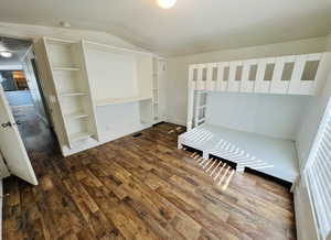 Unfurnished bedroom with dark hardwood / wood-style floors and vaulted ceiling