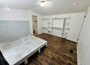 Bedroom with dark hardwood / wood-style floors and vaulted ceiling