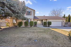 View of front of home with a garage and a front lawn