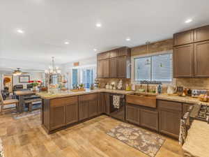 Kitchen featuring sink, hanging light fixtures, kitchen peninsula, stainless steel appliances, and light hardwood / wood-style floors