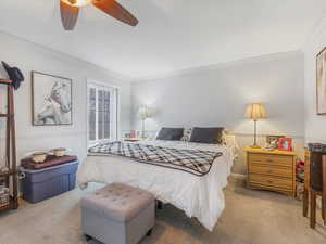 Bedroom featuring ornamental molding, light colored carpet, and ceiling fan