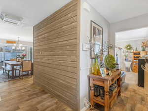 Hallway with hardwood / wood-style flooring and a notable chandelier