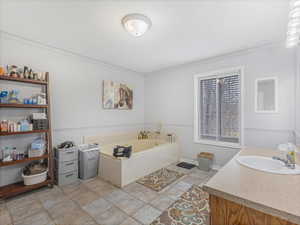 Bathroom with vanity, a bathtub, and ornamental molding