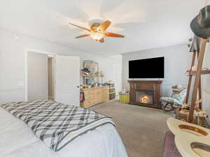 Carpeted bedroom featuring ceiling fan