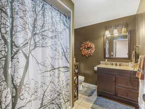 Bathroom featuring vanity, toilet, and tile patterned flooring