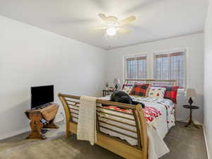 Carpeted bedroom featuring ceiling fan