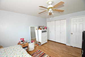 Bedroom featuring hardwood / wood-style flooring, a closet, and ceiling fan