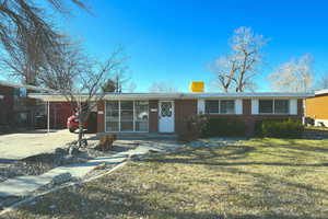 Ranch-style home featuring a carport, a front yard, and central air condition unit