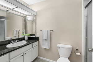 Bathroom featuring vanity, an enclosed shower, and toilet