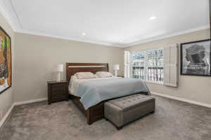 Carpeted bedroom with ornamental molding