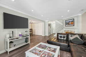 Living room featuring ornamental molding, dark hardwood / wood-style floors, and a chandelier