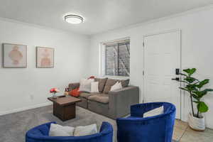 Tiled living room featuring ornamental molding and a textured ceiling