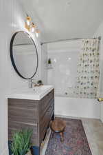 Bathroom featuring tile patterned flooring, vanity, and shower / bathtub combination with curtain