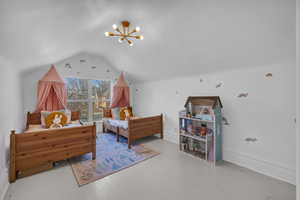 Bedroom featuring lofted ceiling, a notable chandelier, and hardwood / wood-style flooring