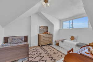 Carpeted bedroom with lofted ceiling