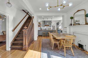 Dining space with light hardwood / wood-style flooring and ornamental molding