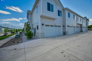 View of side of property with central AC unit, a garage, and a mountain view