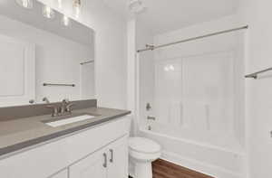 Full bathroom with vanity, toilet, bathing tub / shower combination, and hardwood / wood-style floors