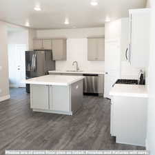 Kitchen featuring sink, gray cabinetry, dark hardwood / wood-style floors, a kitchen island, and stainless steel appliances