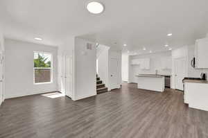 Unfurnished living room with sink and wood-type flooring